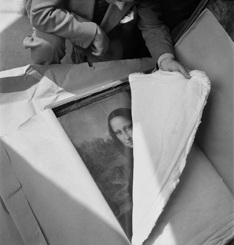 the painting, the mona lisa, is in a box and being unwrapped
